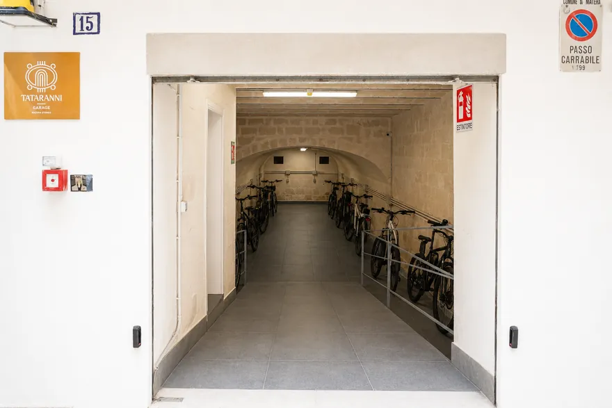 La porta d’ingresso aperta sul corridoio, con le biciclette parcheggiate in fondo