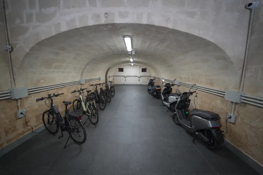 La volta in tufo con biciclette e uno scooter sotto l’arco