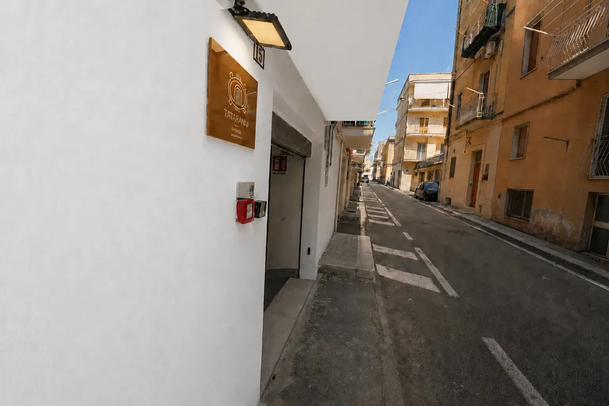 La via davanti al garage, con la targa e l’ingresso sulla sinistra