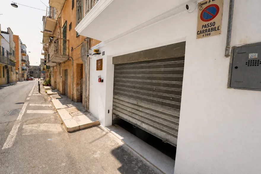 La serranda vista dalla strada, con il cartello di passo carrabile