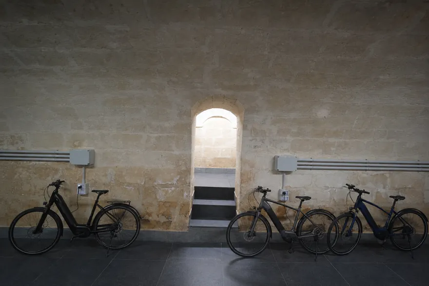 Biciclette parcheggiate accanto a un arco scavato nel tufo